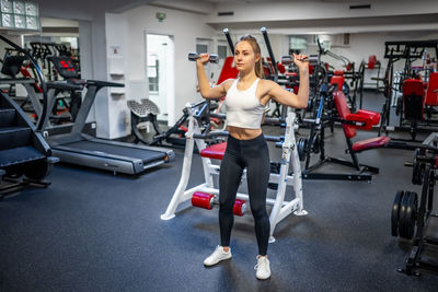 Side view of woman exercising in gym