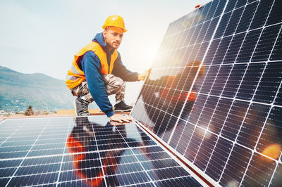 Rear view of man working on solar