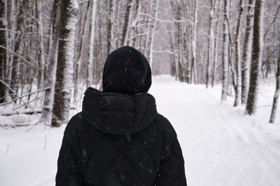 Rear view of woman skiing in forest during winter