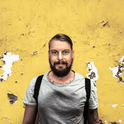 Portrait of mid adult man against yellow wall