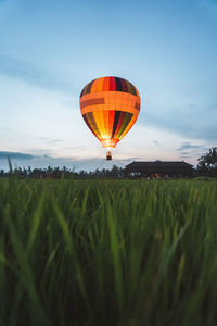 Hot air balloon on field against sky