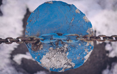 Close-up of rusty chain attached to pole during winter