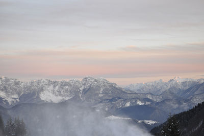 Scenic view of snowcapped mountains against sky during sunset