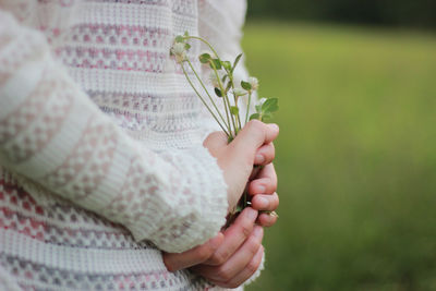 Midsection of woman holding flowers