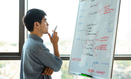 Portrait of young woman standing in office