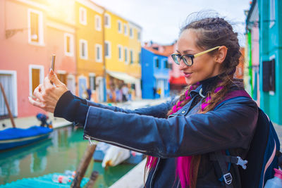 Portrait of young woman wearing sunglasses while standing outdoors