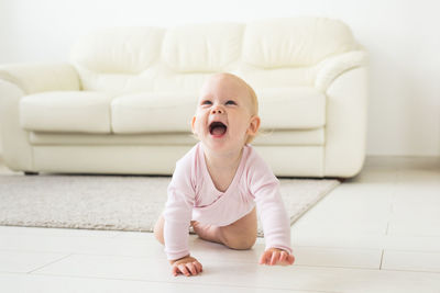 Cute baby girl on sofa at home