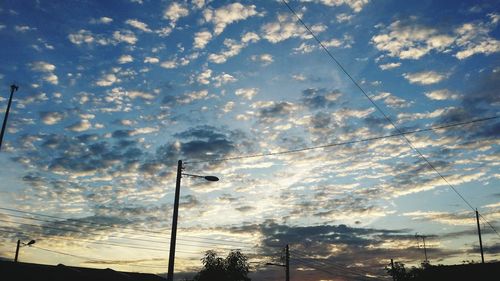 Low angle view of silhouette trees against cloudy sky