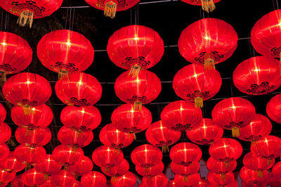 Low angle view of illuminated lanterns hanging against sky at night