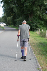 Rear view of man walking on road