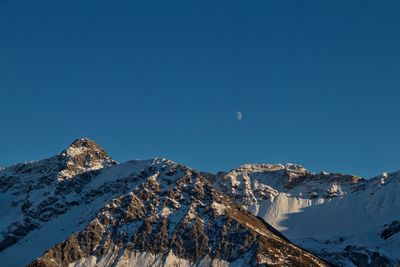 Scenic view of snowcapped mountains against clear blue sky