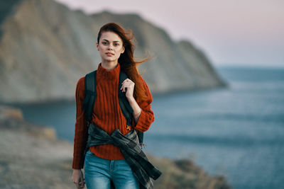 Portrait of young woman standing in sea