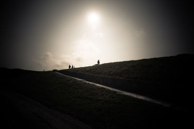 Silhouette people on road against sky