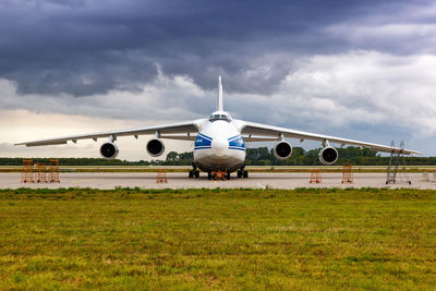 Airplane on airport runway against sky