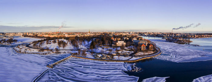 Aerial view of city during winter against blue sky