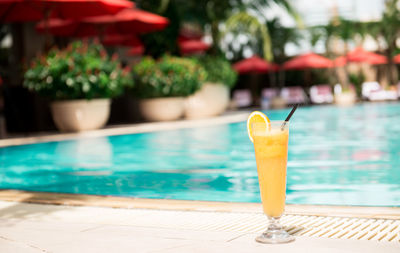 Close-up of drink on table at swimming pool