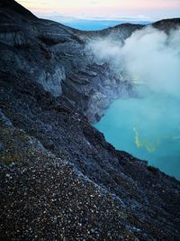 Smoke emitting from volcanic mountain against sky