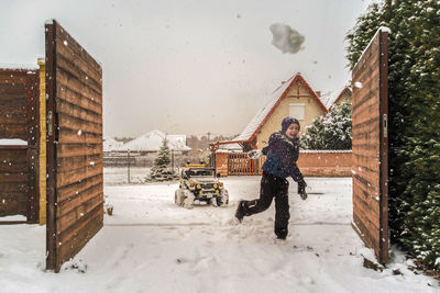 Full length of man standing outside house during winter