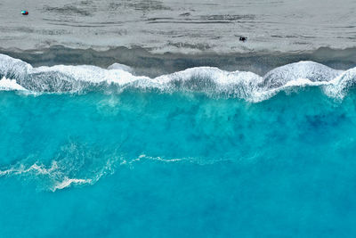 Aerial view of waves rushing towards shore