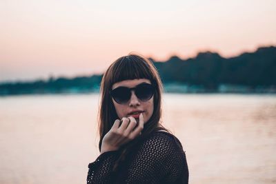 Portrait of beautiful woman against sky during sunset