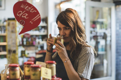 Portrait of woman holding ice cream at store