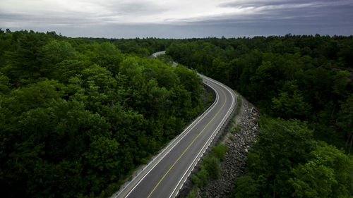 High angle view of road amidst trees against sky