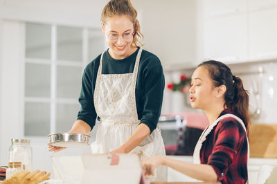 Happy friends standing on table