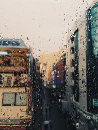 City seen through wet window during rainy season