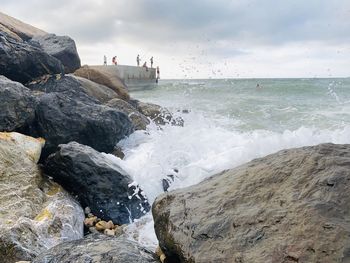 Scenic view of rocks in sea against sky