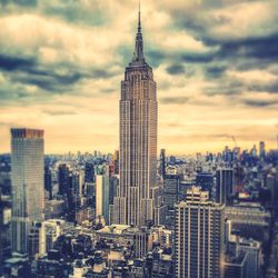 Modern buildings in city against cloudy sky