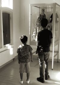 Rear view of friends standing in corridor