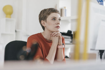 Woman at desk in office looking at computer screen
