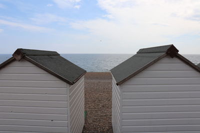 Hut on beach by sea against sky