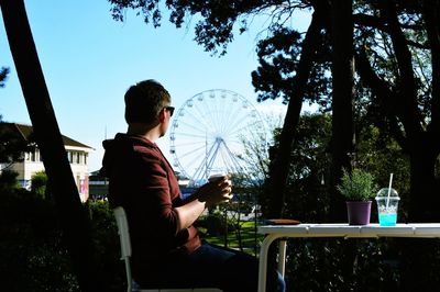 Man holding umbrella against sky