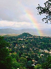 Scenic view of rainbow over mountain against sky