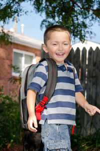 Happy boy with back pack going to school