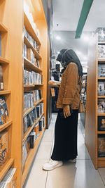 Side view of woman standing at book shop