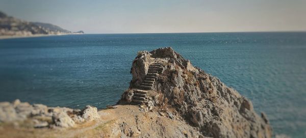 Rock formation on beach against sky