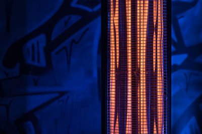 Close-up of radiant heater against blue wall