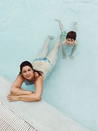 Portrait of young couple swimming in pool