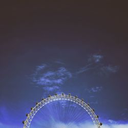 Low angle view of ferris wheel against blue sky
