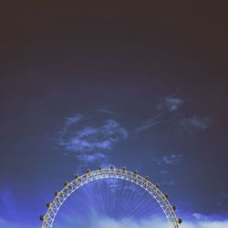 Low angle view of ferris wheel against blue sky