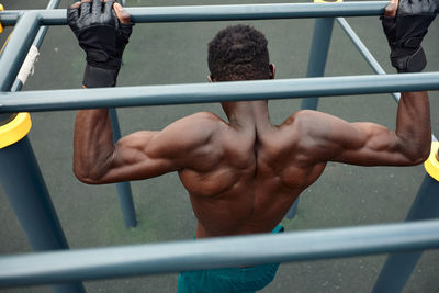 Rear view of man holding metal railing