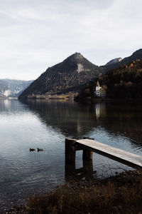Scenic view of lake by mountains against sky