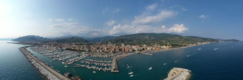 Panoramic view of city by sea against sky