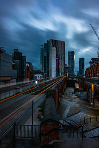 Illuminated buildings in city against sky