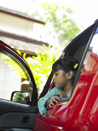 Girl sitting in red car