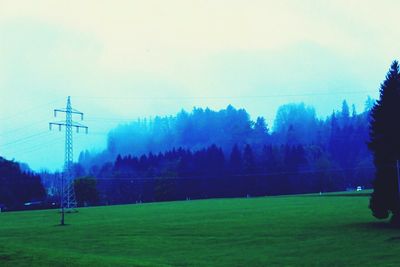 Electricity pylon on grassy field