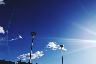 Low angle view of floodlight against blue sky