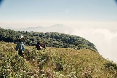 Rear view of women on landscape against sky